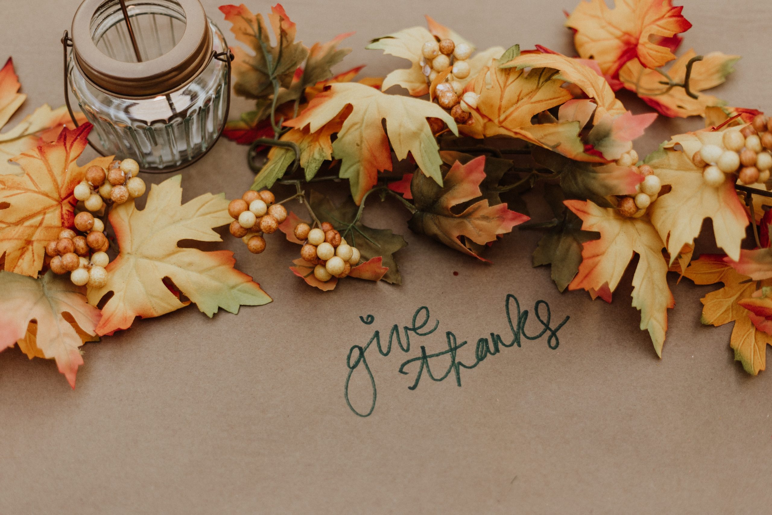 give thanks written on paper table cloth with fall leaves